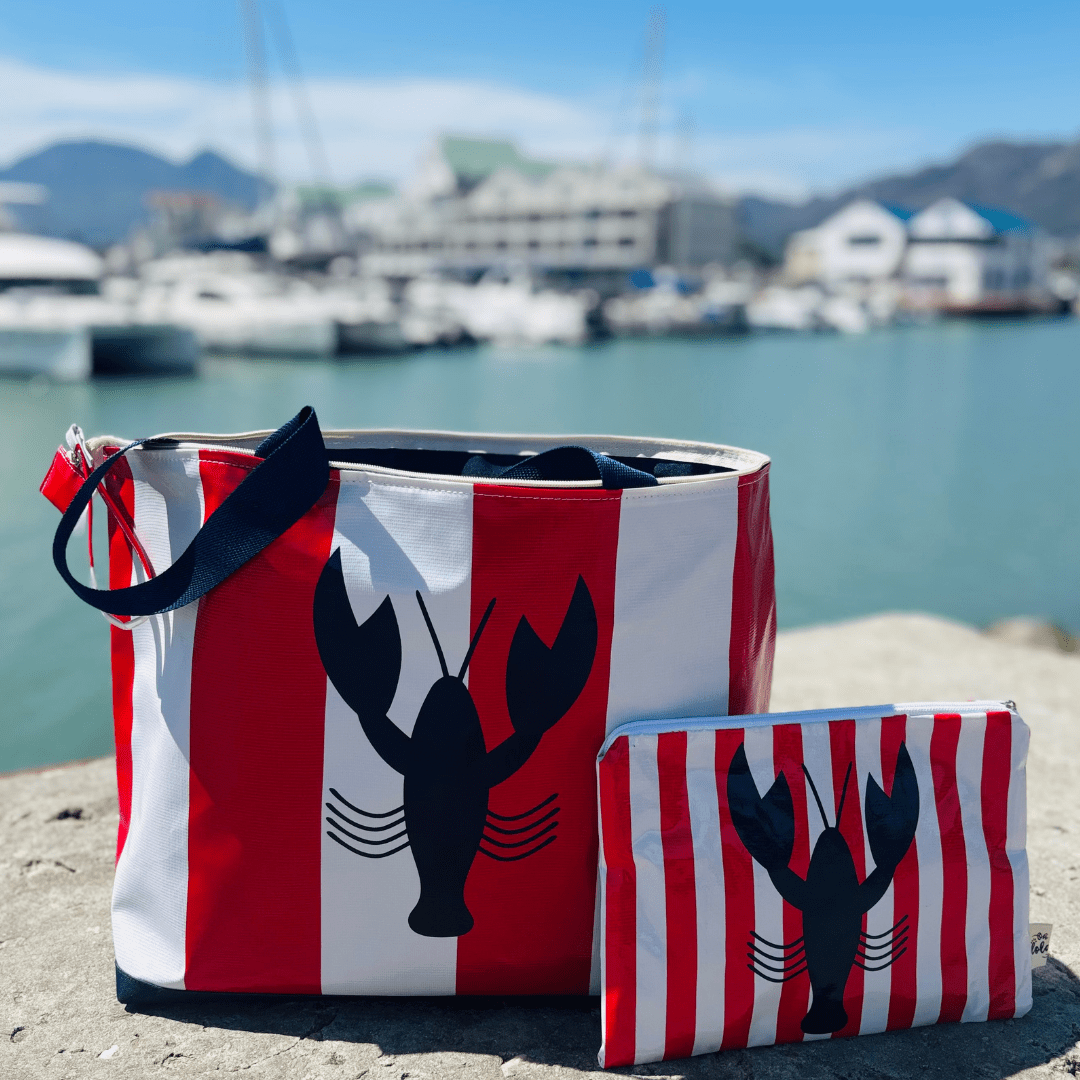 Red and white striped tote bag and pouch with black lobster print by the marina waterfront