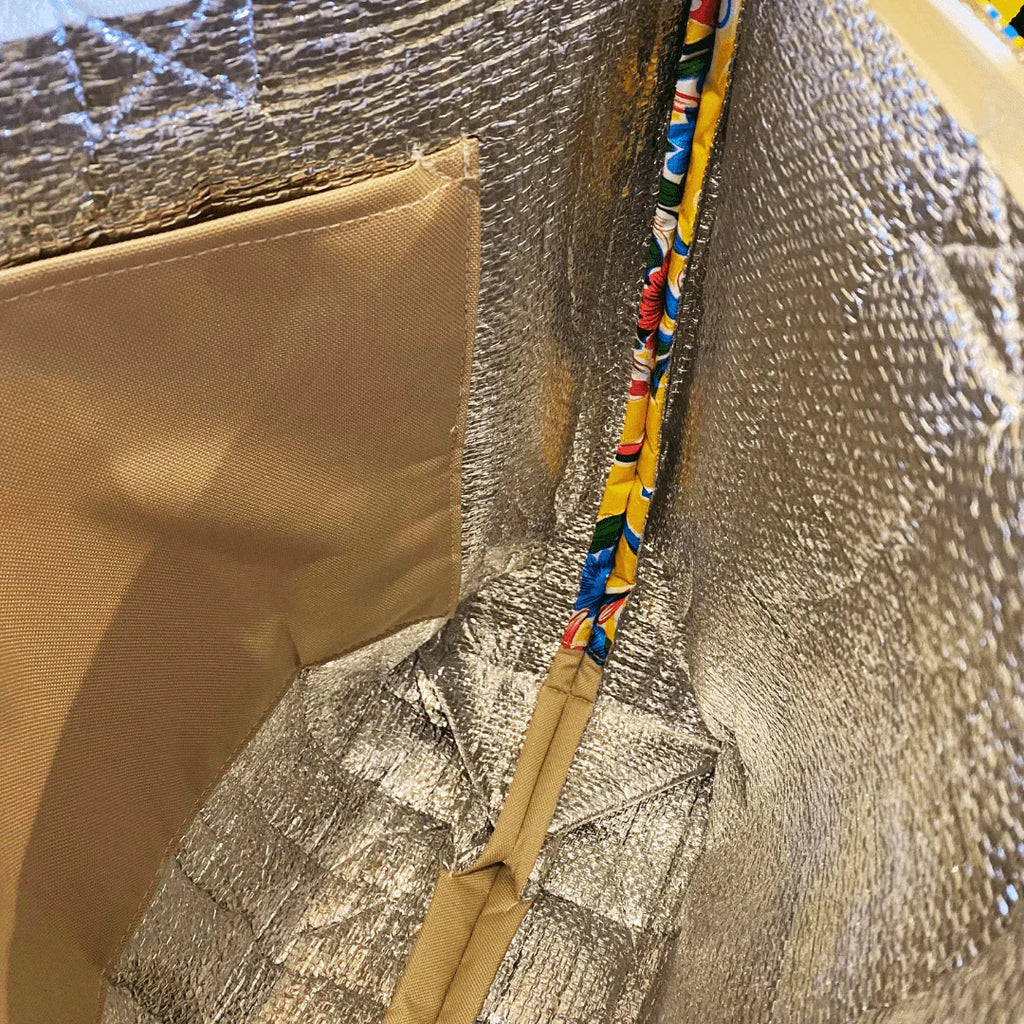 Inside view of insulated silver lunch bag with beige pocket and colorful floral trim