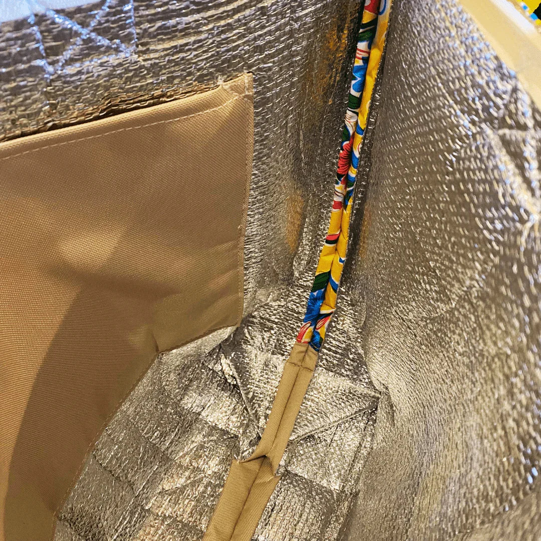 Inside view of insulated silver lunch bag with beige pocket and colorful floral trim