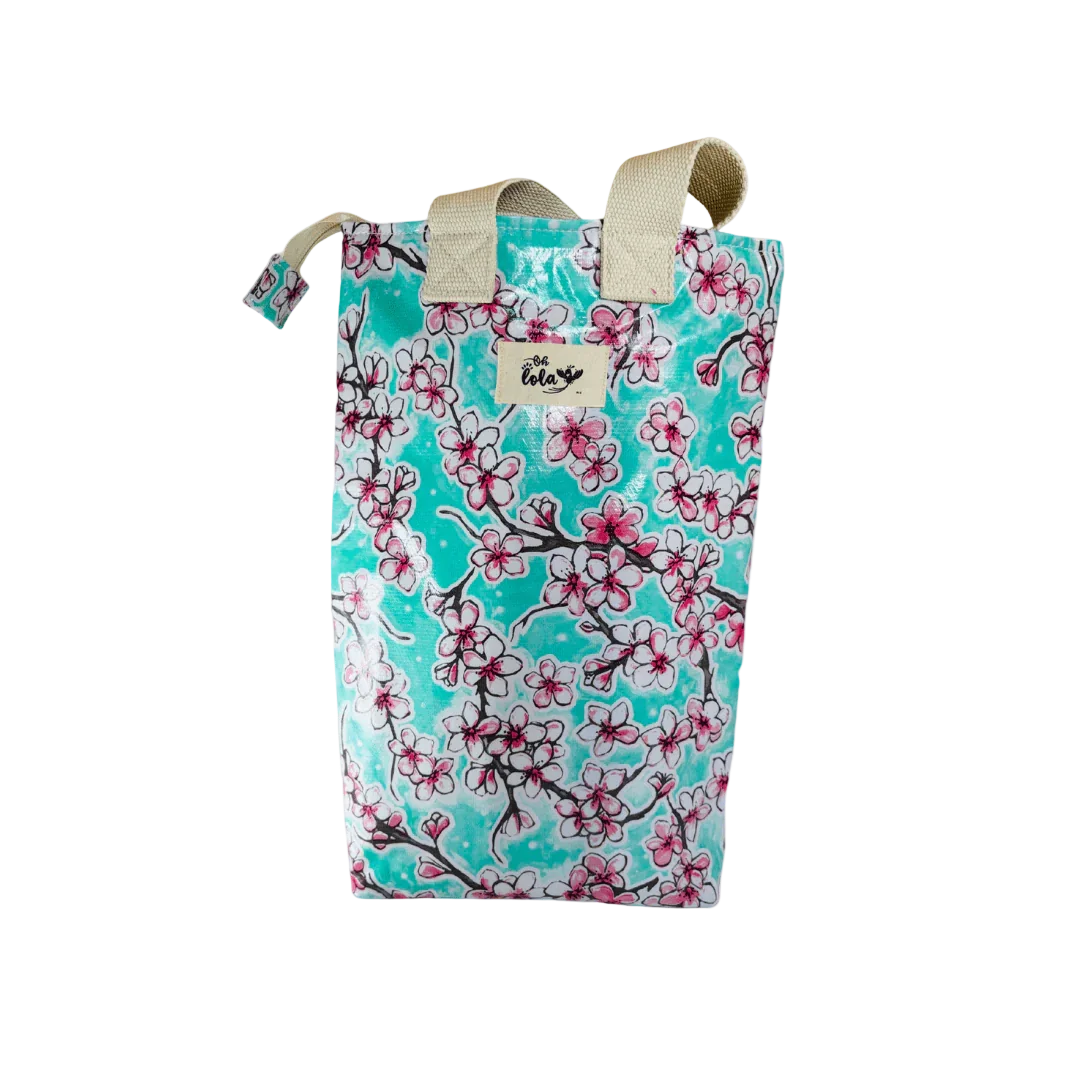 Reusable turquoise tote bag with pink and white cherry blossom print and cream handles