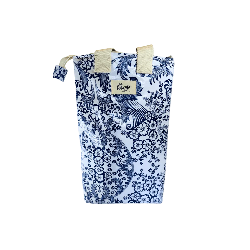 Blue and white floral patterned insulated lunch bag with beige handles and 'oh Lola' label