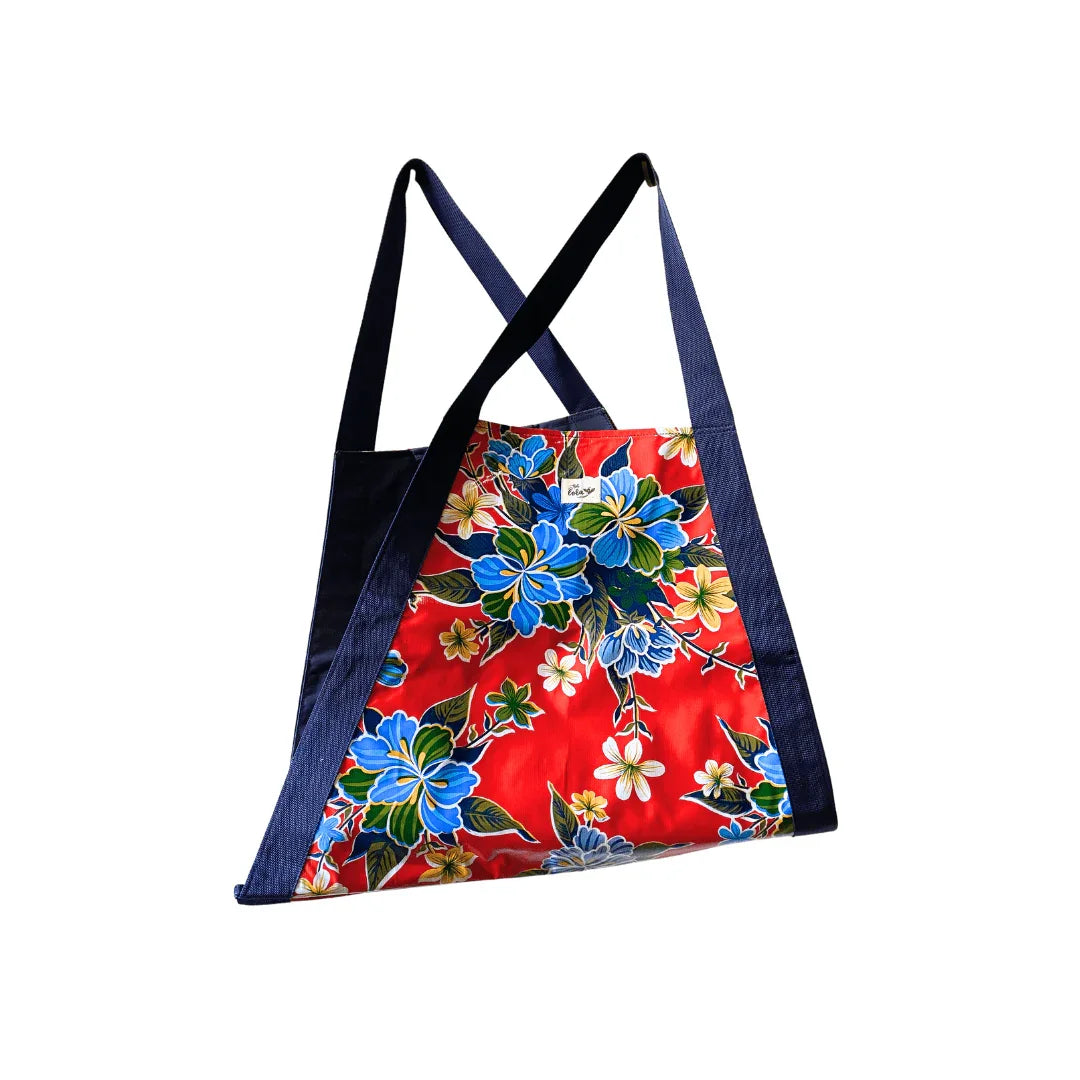 Red floral tote bag with blue flowers and navy blue straps isolated on white