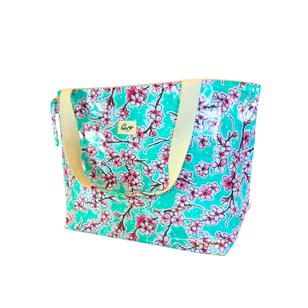 Large turquoise floral tote bag with pink cherry blossoms and beige handles