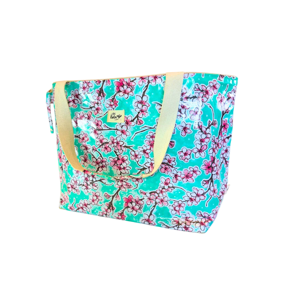 Large turquoise floral tote bag with pink cherry blossoms and beige handles