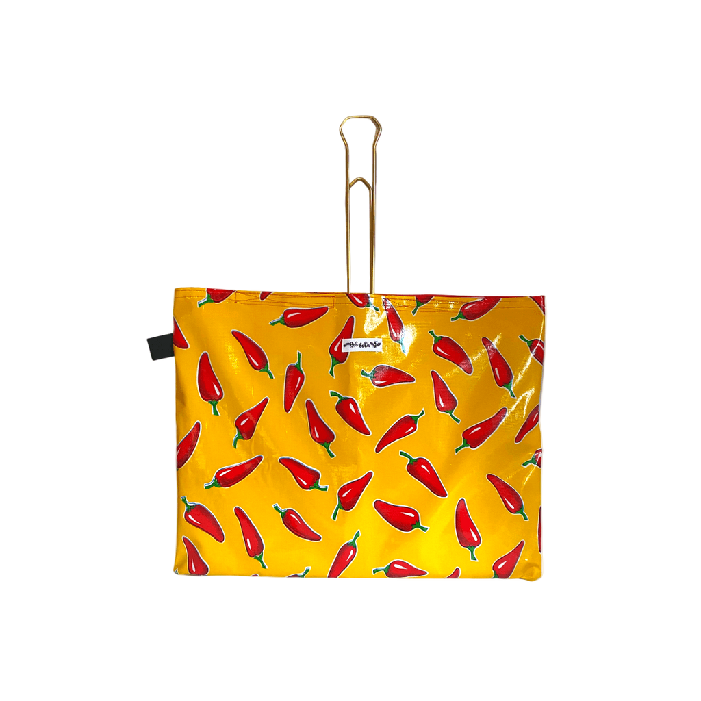 Yellow waterproof bag with red chili pepper print and gold metal handle