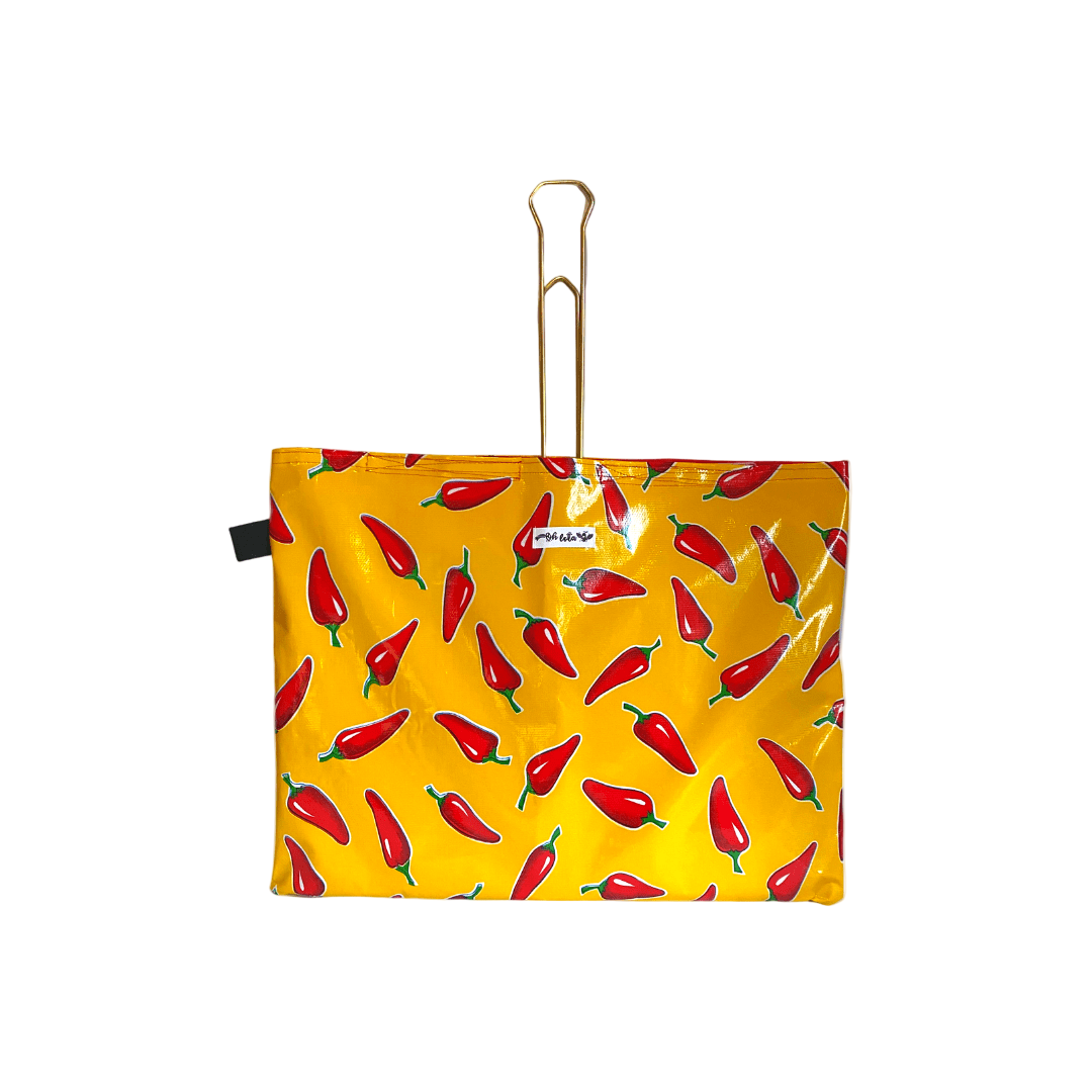 Yellow waterproof bag with red chili pepper print and gold metal handle