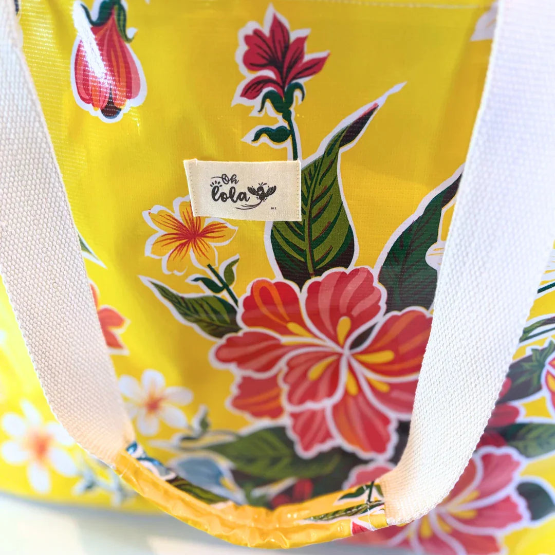 Yellow floral tote bag with white straps and Oh Lola brand label