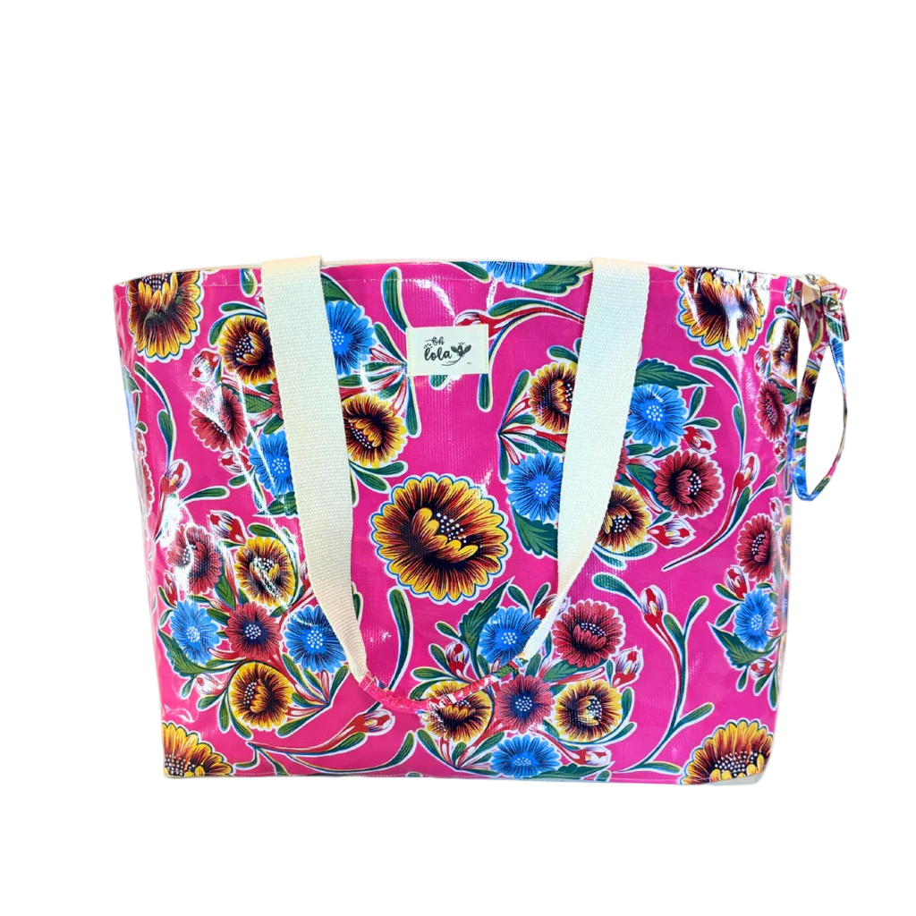 Colorful floral tote bag with pink background and white handles, featured with vibrant blue, red, and yellow flowers