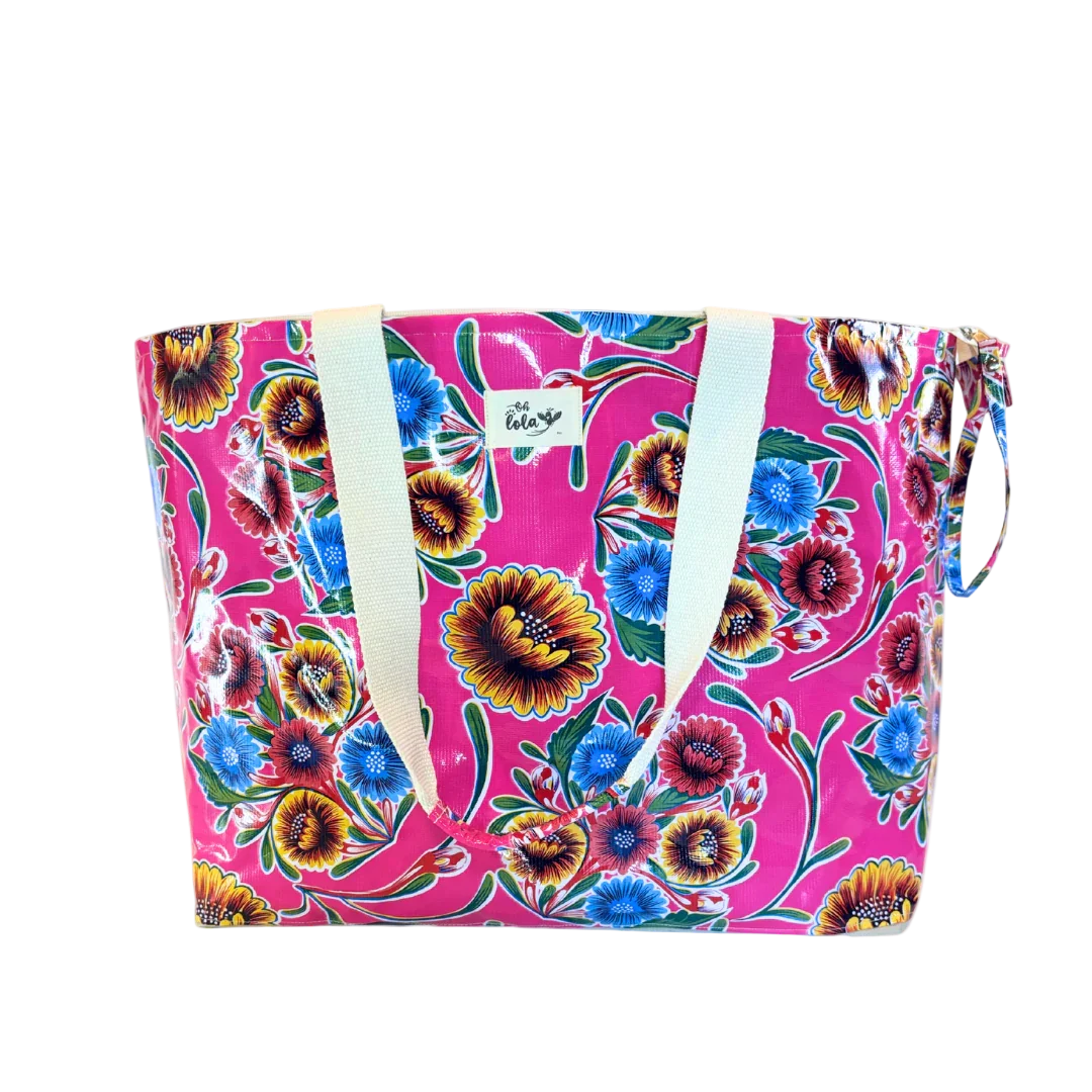 Colorful floral tote bag with pink background and white handles, featured with vibrant blue, red, and yellow flowers