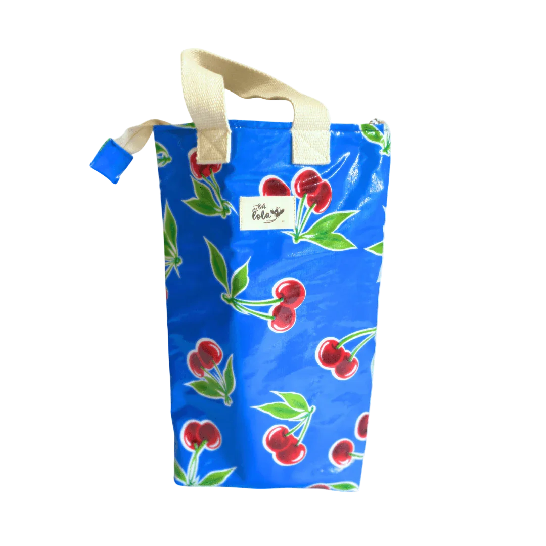 Blue tote bag with red cherry print and beige handles, featuring Oh Lola brand label
